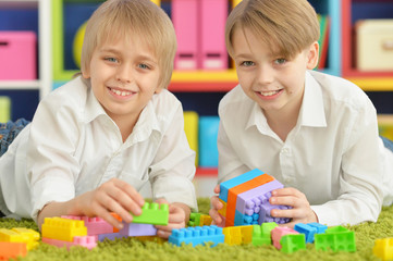 boys playing with colorful plastic blocks 
