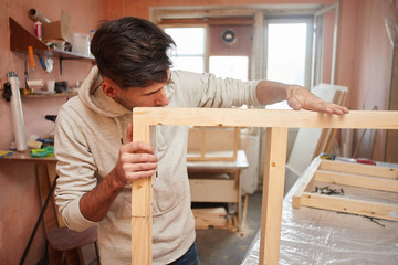 Portrait of a guy working in a home workshop.