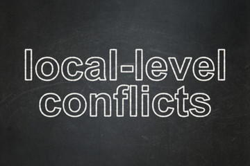 Political concept: text Local-level Conflicts on Black chalkboard background