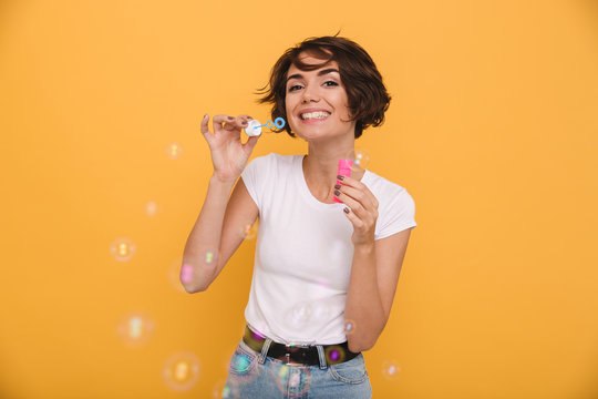 Portrait of a cheerful young girl blowing bubbles