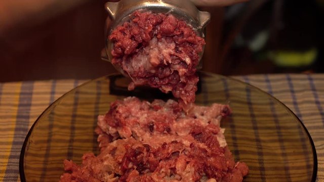 The minced meat.Closeup of fresh meat coming from old manual grinder.