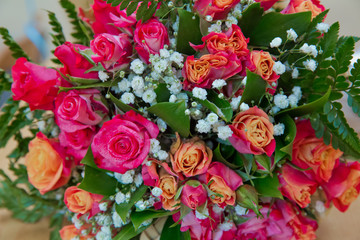 Closeup shot of red bouquet of roses, peonies, pomegranates. Love and passion symbol. Anniversary or birthday gift for girl.