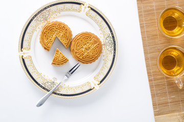 Top view of moon cake and tae on white.