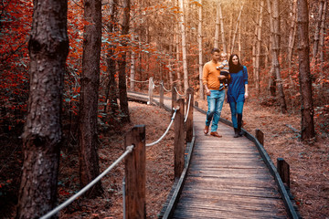 A young couple walks in the woods with a little boy