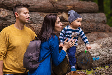 A young couple walks in the woods with a little boy