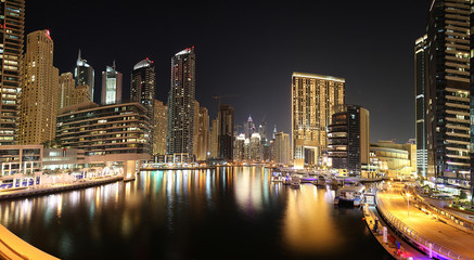Fototapeta na wymiar Panoramaaufnahme in Dubai von der Skyline im Stadtteil Marina in der Nacht mit Wasserspiegelung im November 2013