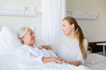 daughter visiting senior mother at hospital