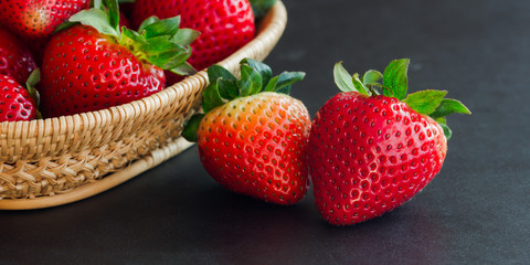 Goodness ripe strawberries on granite table with copy space use for web banner or cover and other web design. Red freshness strawberry on black isolated background in low key or still life concept.