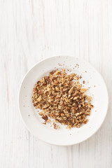 Roast chopped walnuts in a white plate