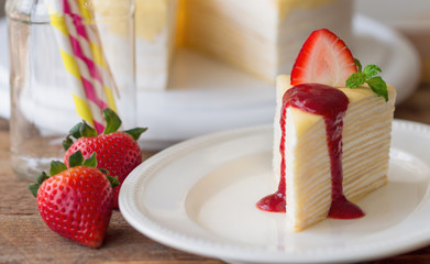 Homemade crepe cake and strawberries sauce decorate by mint and fresh strawberry so delicious soft sweet and sour for birthday party or coffee break. Crepe cake or mille crepe is French dessert.