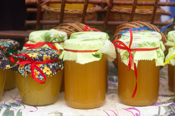 Honey in glass jars at an agricultural exhibition.