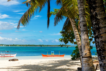 Tropical Guyam Island with traditional fishing boats