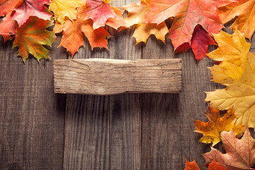 autumn background with signboard, orange leaf on old grunge wood deck, copy place for inscription, Top view, tablet for text.