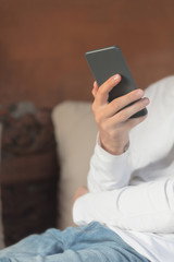 Man sitting on a sofa and using cellphone.