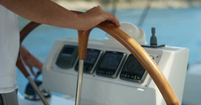 Close-up of a Skipper Holding Sailing Yacht's Steering Wheel. Dashboard Shows Knots, Degrees and Wind Direction. Calm Sea in the Background. Shot on RED Epic 4K UHD Camera.