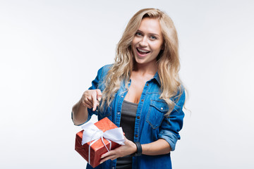 Pretty young woman pointing at gift box