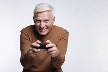 Excited senior man playing video game