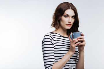 Fototapeta premium Beautiful auburn-haired woman holding a cup of coffee