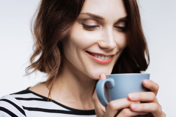 Close up of beautiful woman smelling coffee aroma