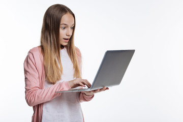 Cute teenage girl looking surprised while reading email