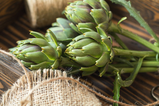 Supplies and materials for artichoke bouquet on wooden background