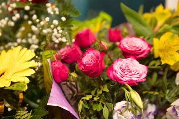 small pink roses in  bouquet among other flowers close up