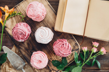 Blueberry meringues and flowers on wooden background. Cooking book.
