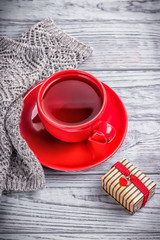 Happy Valentine's Day. Tea, knitted things and a gift in a box with a red heart. Gray wooden background
