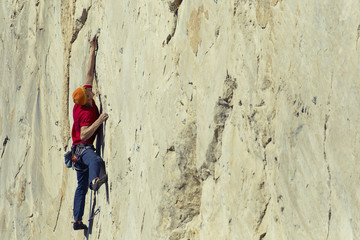 The climber climbs to the top of the mountain.
