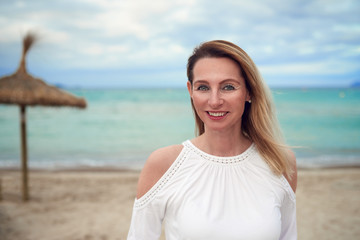 Fototapeta na wymiar Attraktive modische Frau steht am Strand