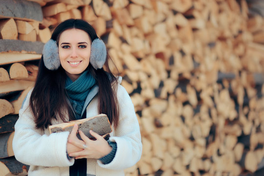 Smiling Girl in Front of Fire Wood Stack Ready for Winter