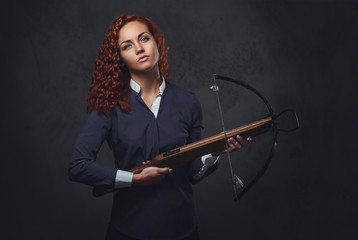 Redhead female  holds crossbow.