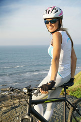 Athletic girl on bike ride, relaxing by the sea