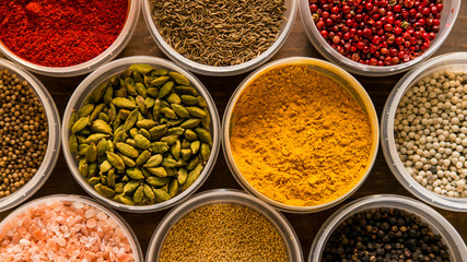 Various colorful spices in plastic containers