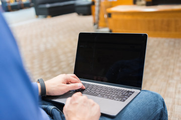 Male works on personal laptop in library