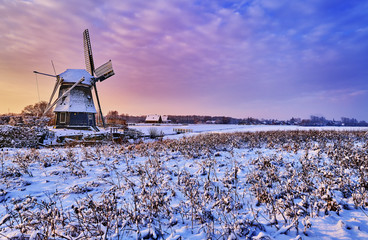 Dutch windmill in the snow of a holland winter © the_lightwriter