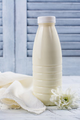 Fototapeta na wymiar Fresh organic cow milk in a plastic bottle on wooden table. Rustic stule. Copy space