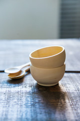 Empty wooden bowls and spoons on wooden background