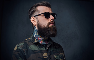 Portrait of bearded tattooed hipster male dressed in a military 