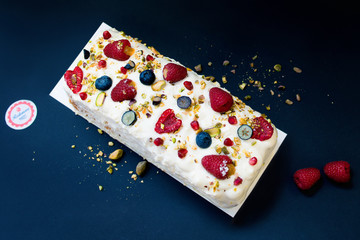 Cake with butter cream and raspberries on dark background