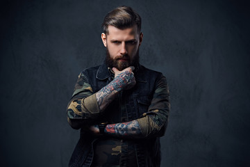 Portrait of bearded tattooed hipster male dressed in a military 
