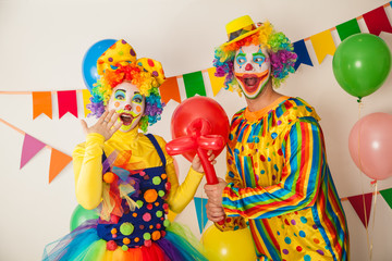 Two cheerful clowns. Birthday for children. Bright clown and clowness.