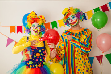 Two cheerful clowns. Birthday for children. Bright clown and clowness.