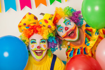 Two cheerful clowns. Birthday for children. Bright clown and clowness.