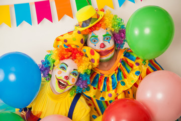 Obraz na płótnie Canvas Two cheerful clowns. Birthday for children. Bright clown and clowness.
