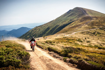 Enduro bikers crossing road in Carpathian mountains. © Dmytro Panchenko