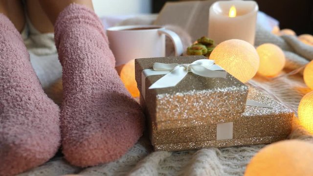 Christmas Time With Girl In Cosy Socks And Gifts. Closeup. 4K. Slow Motion. 