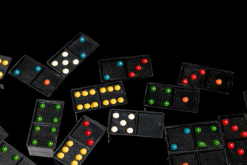 Domino figures are spread on black reflective background