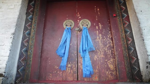 Entrance to a Buddhist temple, with blue scarves and lion heads.