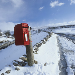 Traditional Red Postbox in a rural setting in the Snow